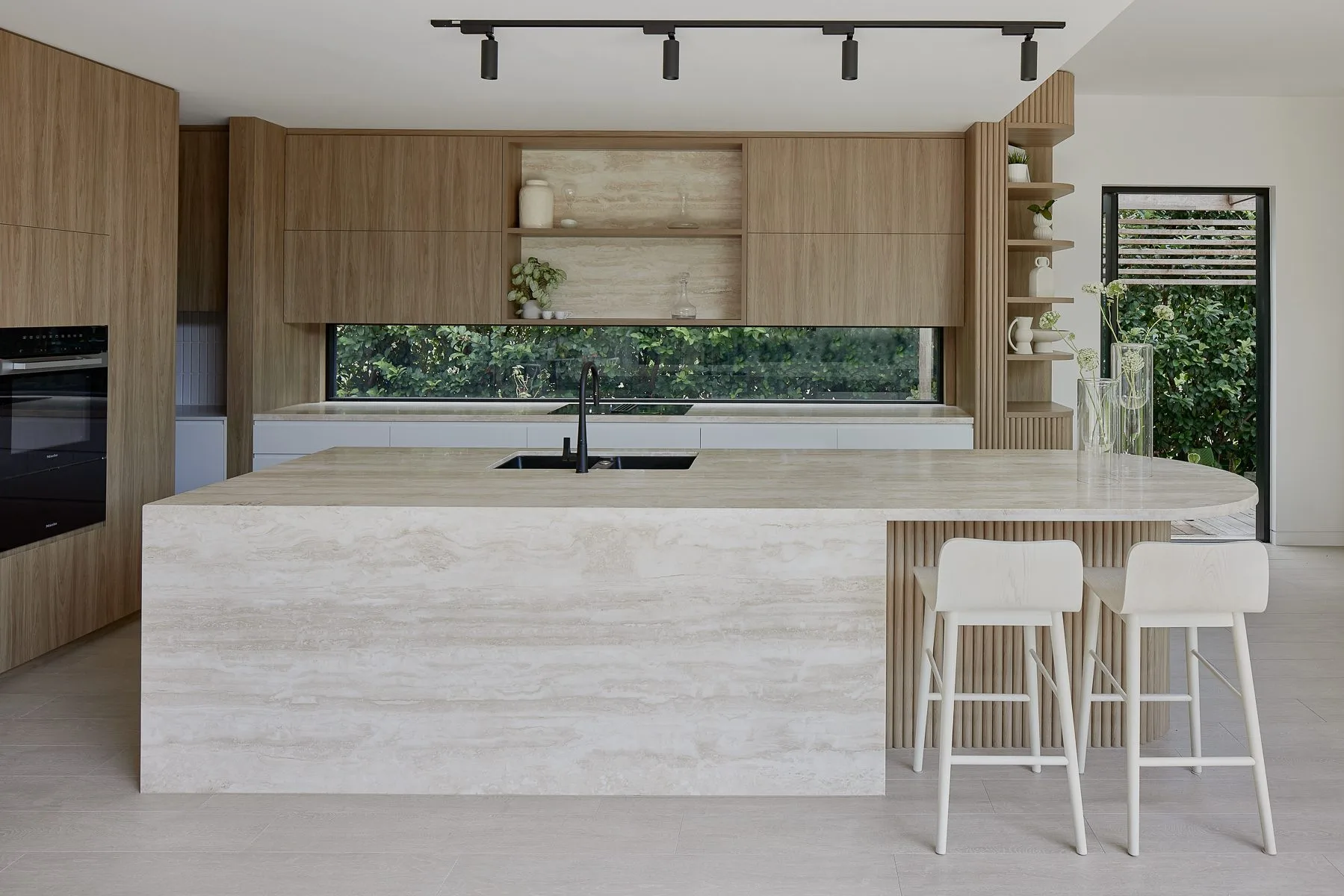 Kitchen with a travertine island and timber joinery, Clayfield House